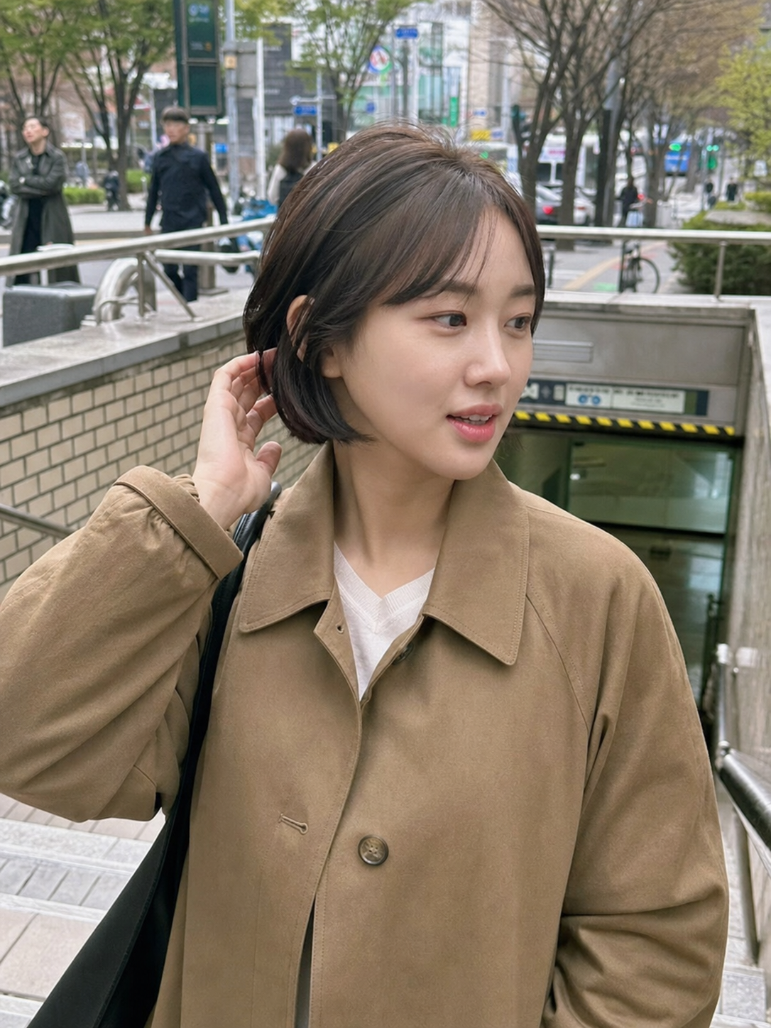 지하철역 앞에서 담긴 정돈된 숏컷 실루엣