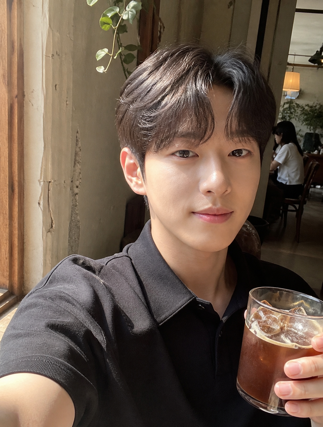 카페 창가에서 자연광으로 찍은 깔끔한 짧은 남자머리 셀피