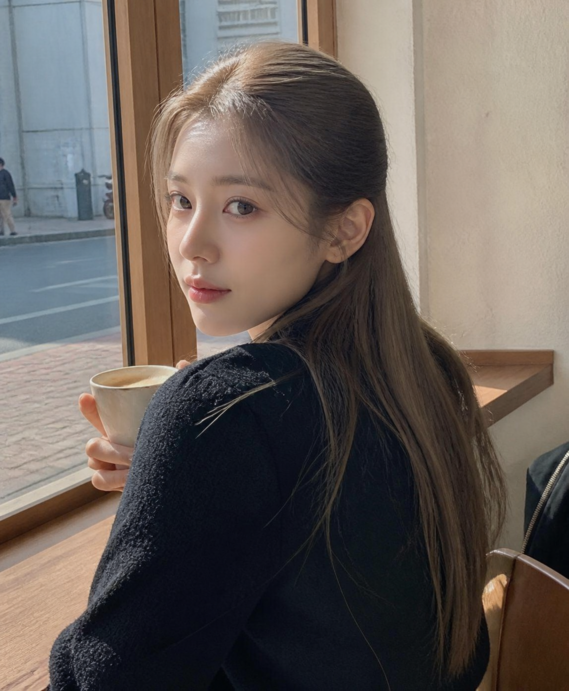 카페 창가에서 자연스럽게 넘긴 긴 머리 셀피